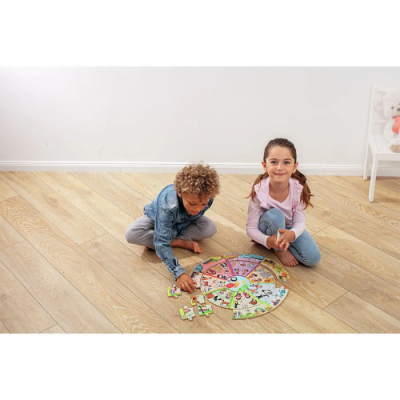 Crianças a jogar jogo de tabuleiro colorido no chão de madeira clara