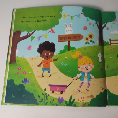 Página ilustrada de livro infantil com crianças, coelhos e texto 'Caça aos ovos'.