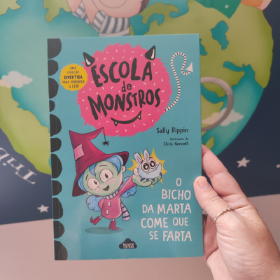 Capa de livro infantil 'Escola de Monstros' com personagens e texto em azul e rosa