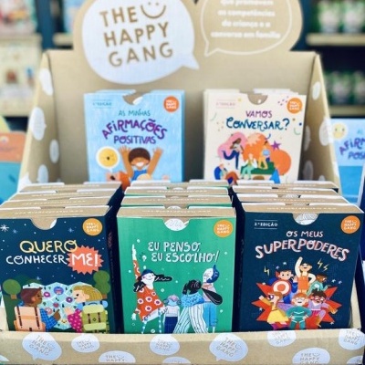 Expositor com livros infantis coloridos da coleção The Happy Gang em português