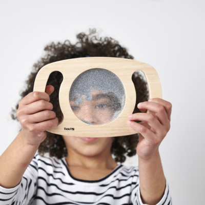 Criança a segurar moldura de madeira com lente circular