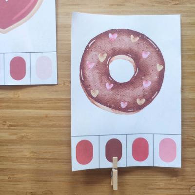 cartão com desenho de donut chocolate com corações e amostras de cor em madeira