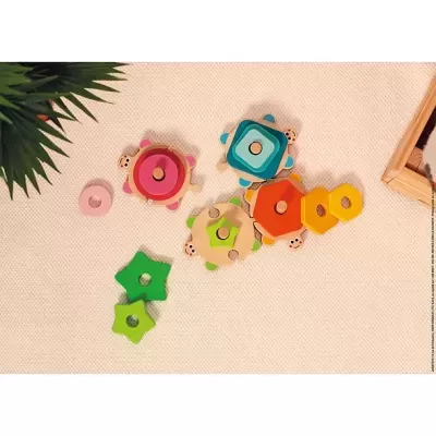 Brinquedos de madeira coloridos com formas geométricas sobre tecido bege