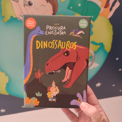 Caixa de jogo infantil com tema dinossauros, texto em português e ilustrações coloridas.