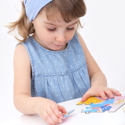 Criança a montar puzzle colorido de madeira