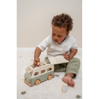 Criança a brincar com autocaravana de brinquedo em madeira sobre tapete
