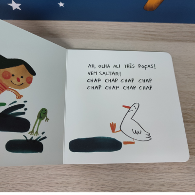 Página dupla ilustrada de livro infantil com texto em português e desenhos de criança, rã e pato junto a poças de água.