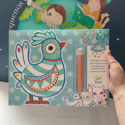 Caixa azul claro com bolinhas brancas contendo um brinquedo de coloração com ilustração de pássaro e lápis cor de madeira.