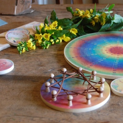 Jogo redondo colorido com peças de madeira e flores amarelas sobre mesa de madeira