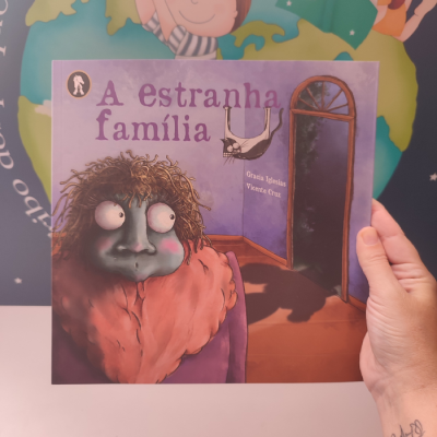 Capa de livro infantil 'A estranha família' com ilustração de pessoa e morcego