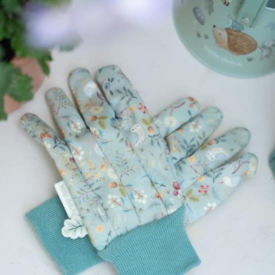 Luvas de jardim azuis com padrão floral e pássaros, junto a frasco verde com ilustração