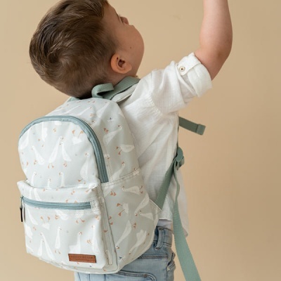 Criança com mochila branca e padrão de gansos