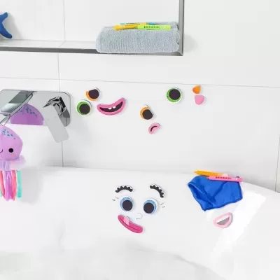 Banheira com adesivos de rosto sorridente e objetos de higiene