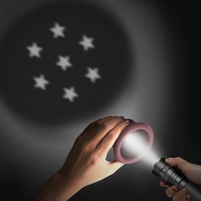 Lanterna e anel rosa projetando estrelas brancas no escuro