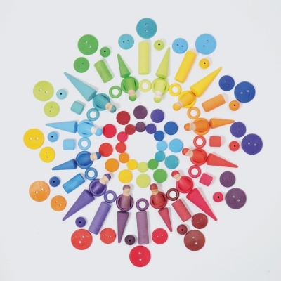 Peças plásticas coloridas organizadas em círculo sobre fundo branco