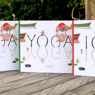 Três livros de yoga com capas brancas e ilustrações coloridas sobre mesa de madeira