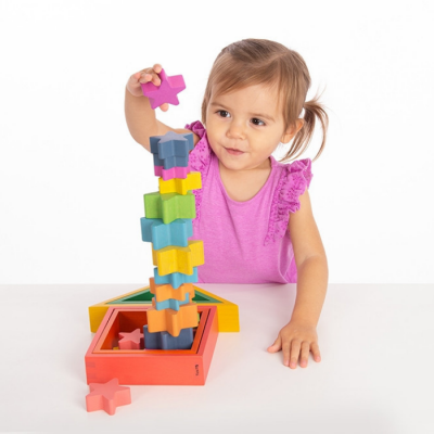 Criança a empilhar blocos de madeira coloridos em forma de estrelas.