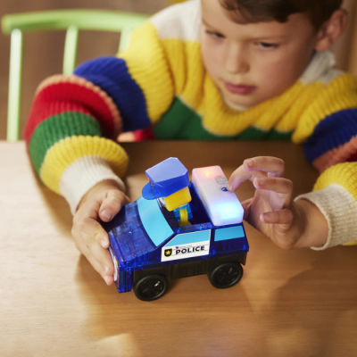 Carrinho de polícia de brinquedo plástico azul com luzes, usado por criança com camisola colorida