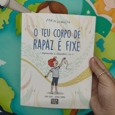 Capa de livro infantil sobre o corpo de rapaz, com ilustração de criança ruiva e texto em azul.