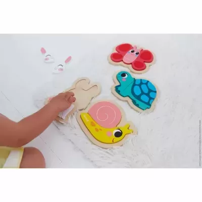 Brinquedos de madeira para encaixe com figuras de caracol, tartaruga, borboleta e outra em superfície branca felpuda