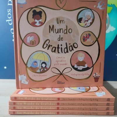 Capa do livro 'Um Mundo de Gratidão' com ilustrações e texto em fundo salmão
