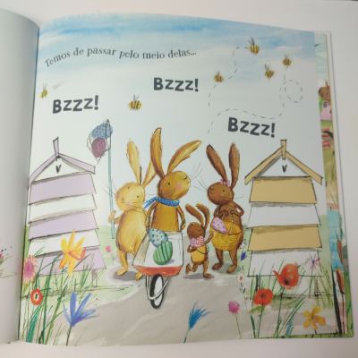 Ilustração infantil com coelhos e zangões em campo florido junto de cabanas de madeira.