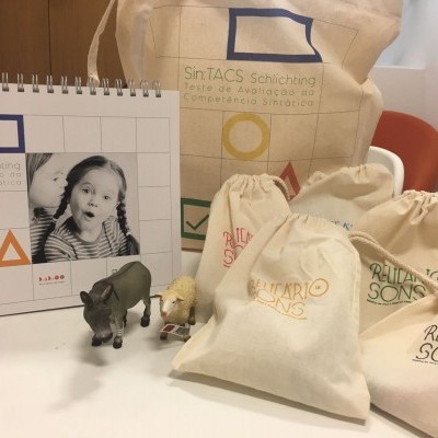 Calendário, sacos de pano personalizados e brinquedos numa mesa branca