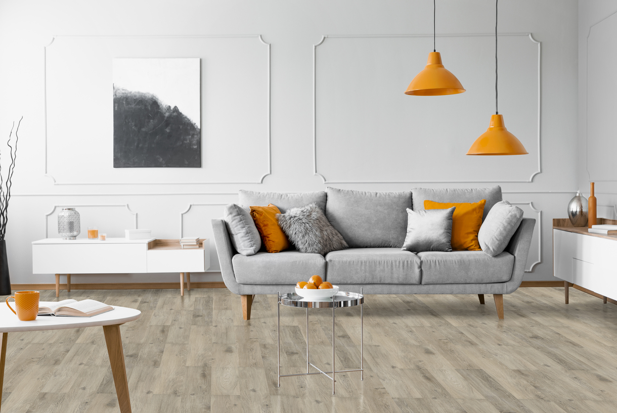 GRIT 1527 GITARO — Pavimento LVT & SPC Série VIVA Modern living room with grey sofa, orange cushions and lamps, light wood flooring, and white furniture
