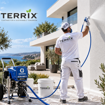 Pintor profissional aplicando revestimento branco com equipamento GRACO ULTRA MAX II e tinta TERRIX em parede exterior com vista para o mar.