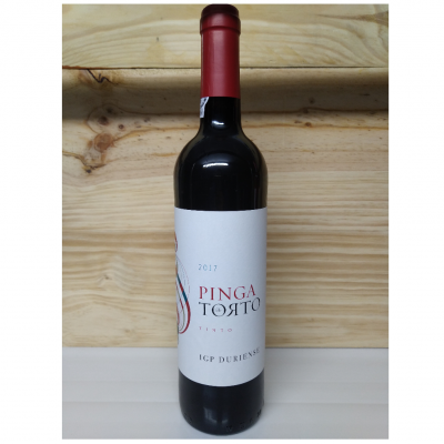 Garrafa de vinho tinto com rótulo branco e tampa vermelha sobre superfície branca e fundo de madeira