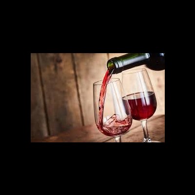 Vinho tinto a ser servido em copos sobre mesa de madeira