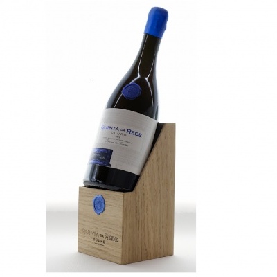 Garrafa de vinho tinto com rolha azul numa base de madeira clara