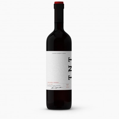 Garrafa de vinho tinto com rótulo branco e tampa preta e vermelha