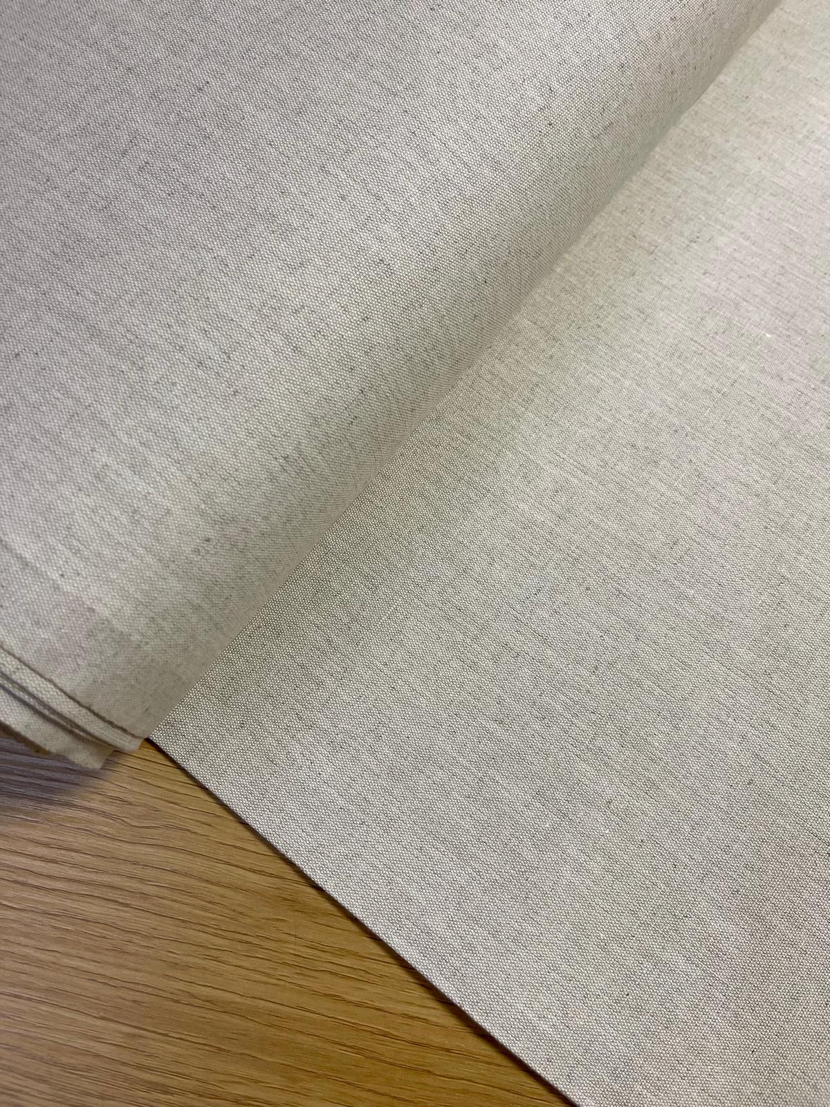 Rolo de tecido bege claro e madeira clara