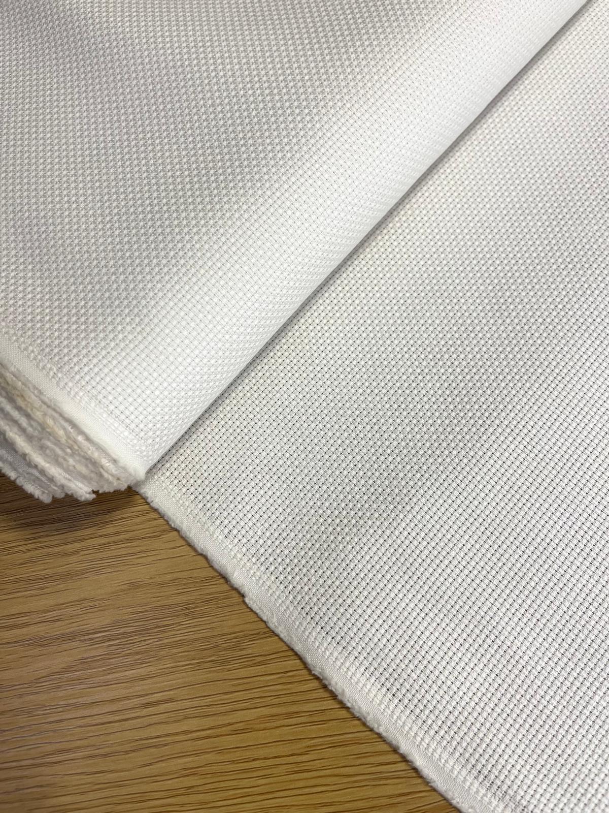 Tecido branco com textura de malha quadrada sobre madeira clara