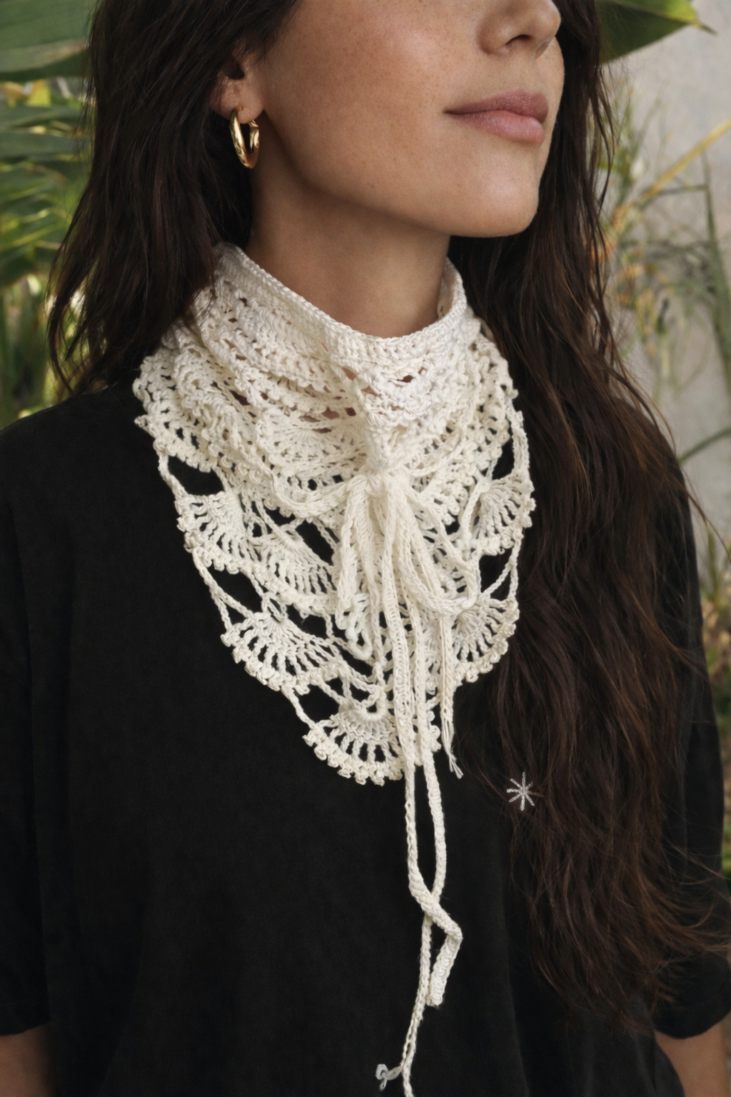 Cachecol triangular em crochê branco com padrão rendado e franjas