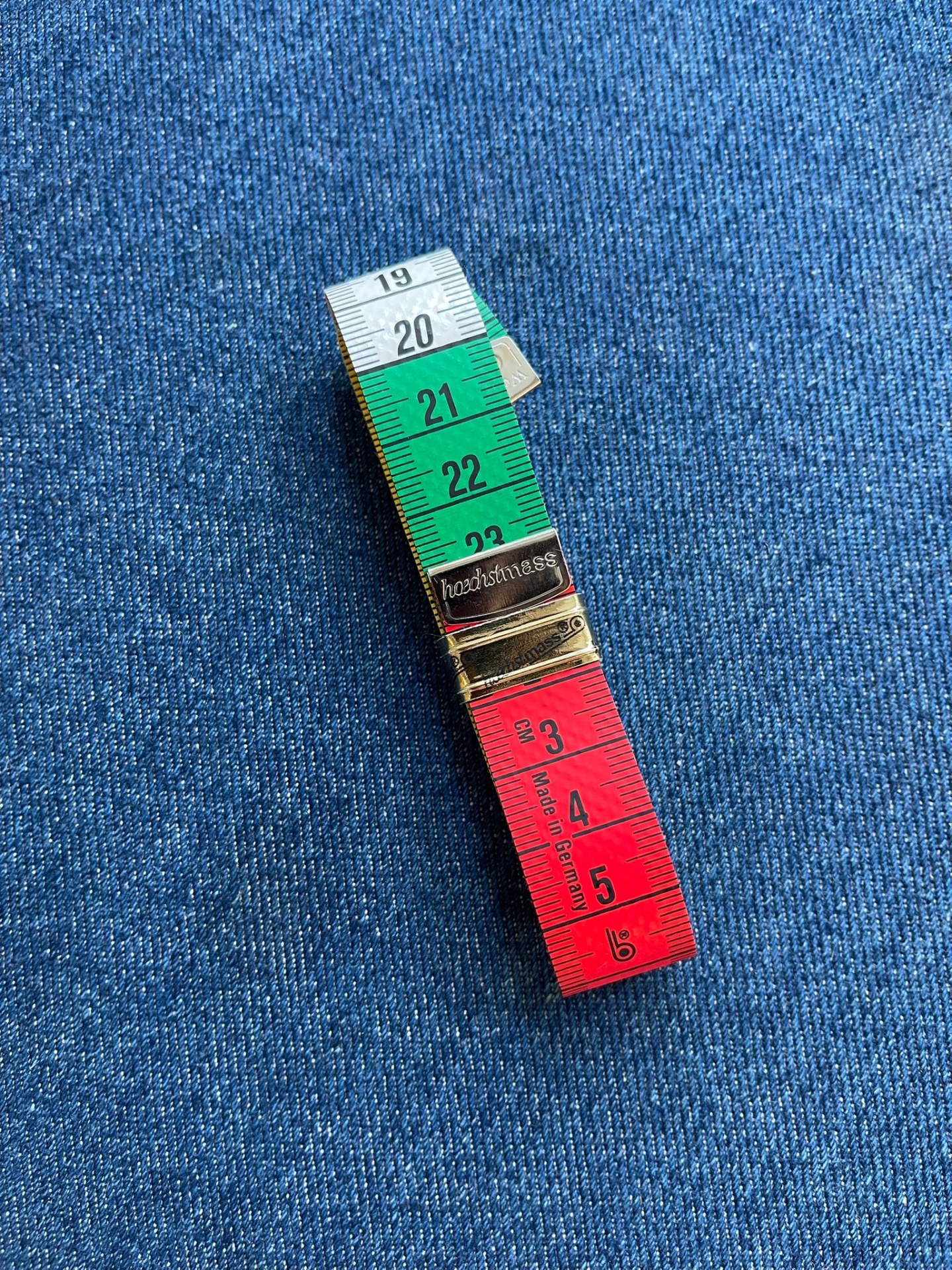 Fita métrica colorida sobre tecido de ganga azul