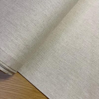 Rolo de tecido bege claro e madeira clara