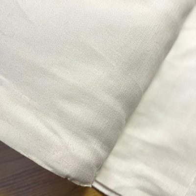 Lençol branco de algodão dobrado sobre madeira