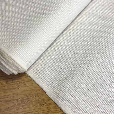 Tecido branco com textura de malha quadrada sobre madeira clara