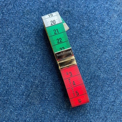 Fita métrica colorida sobre tecido de ganga azul