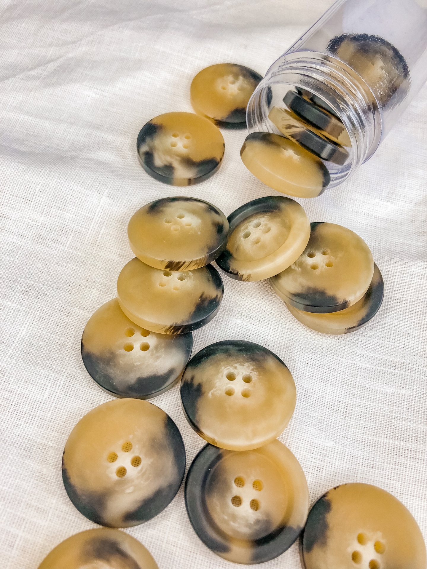 Botões redondos marmoreados em tons castanhos e pretos com quatro furos