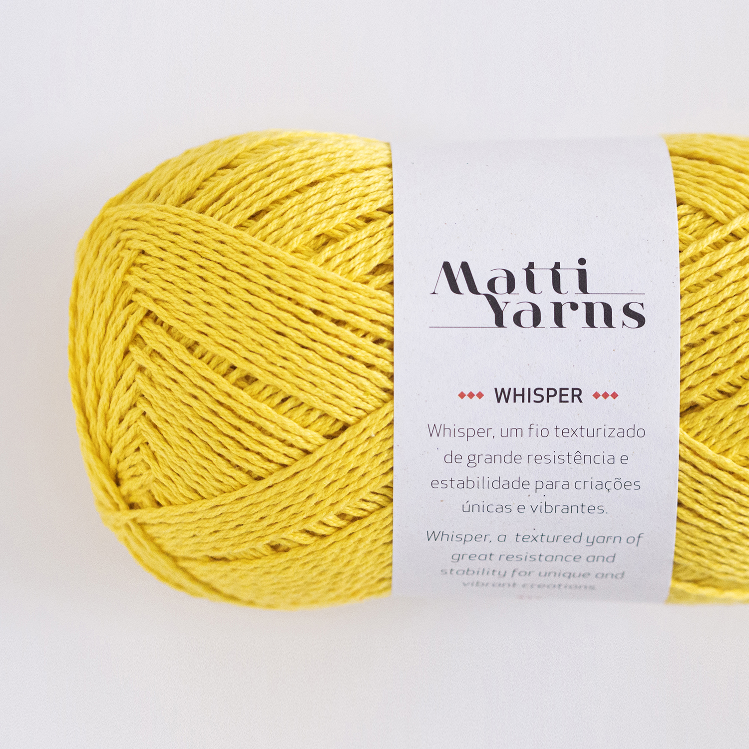 Novelo de fio amarelo texturizado Matti Yarns com etiqueta branca.