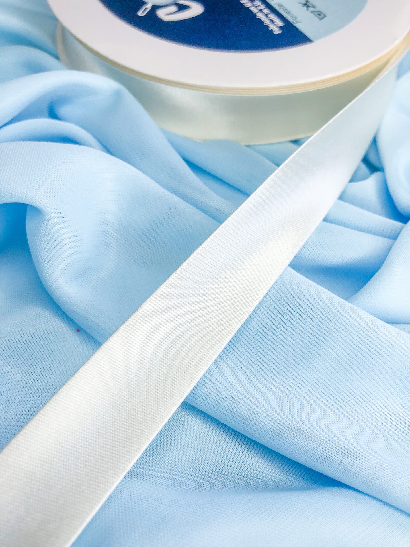 Fita branca de tecido sobre tecido azul claro
