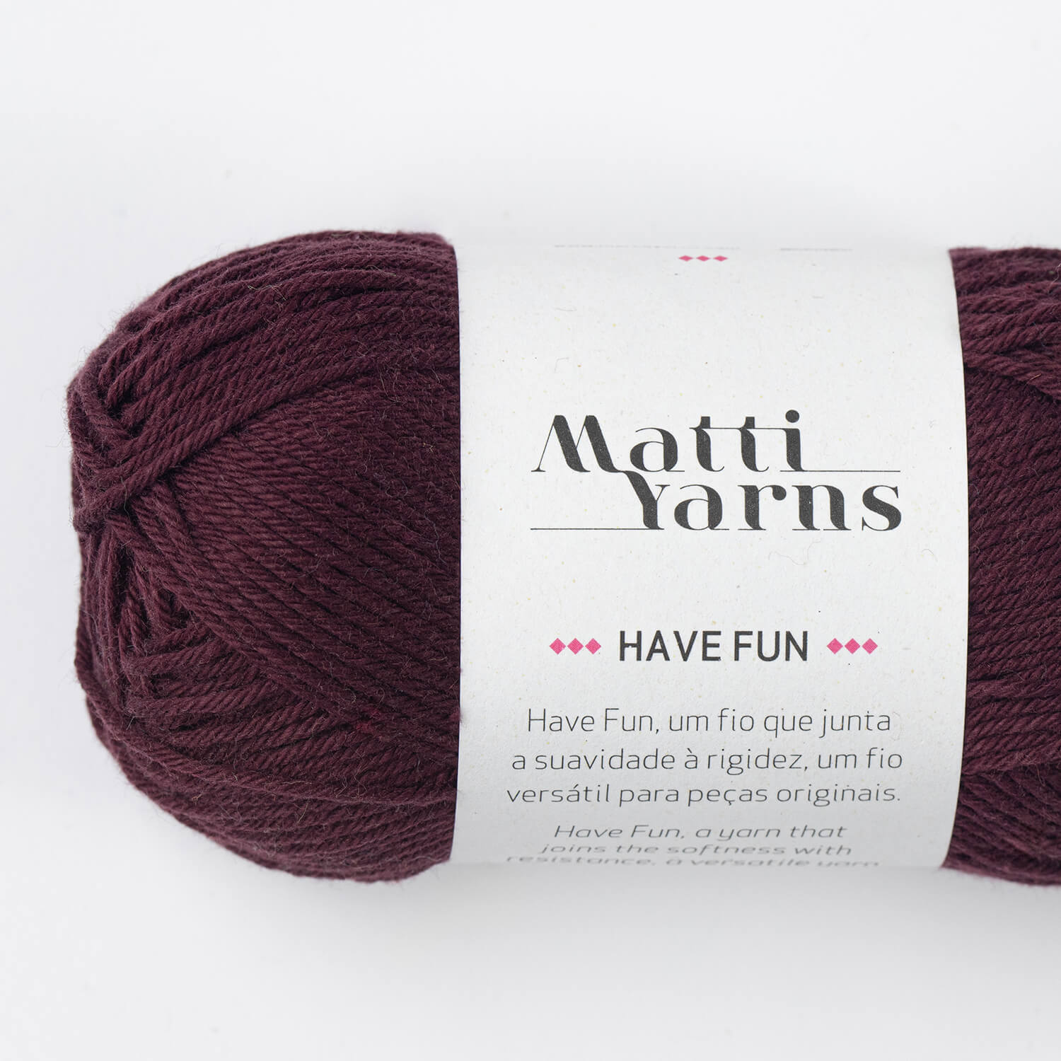 Novelo de fio bordeaux da marca Matti Yarns com rótulo branco contendo texto descritivo.
