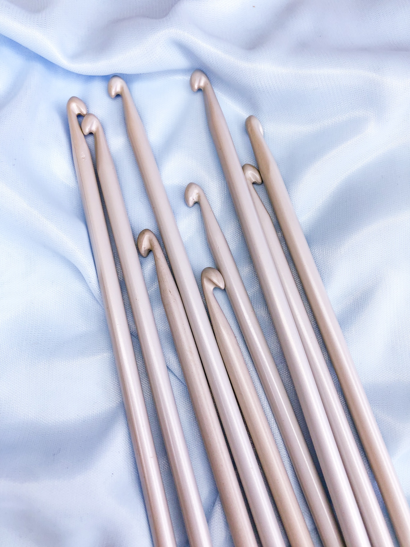 Conjunto de agulhas de tricô metalizadas em tecido branco