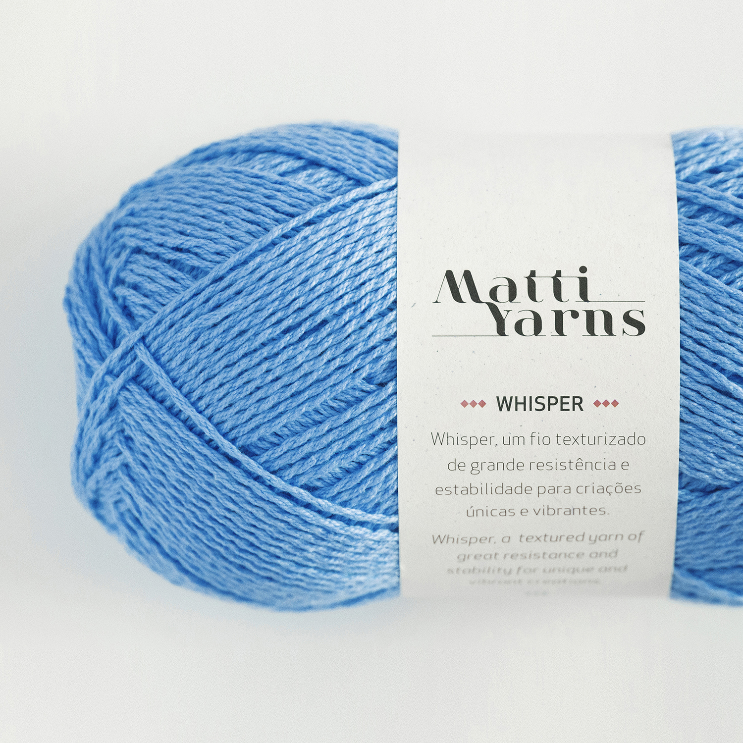 Novelo de fio azul claro com etiqueta branca 'Matti Yarns Whisper'