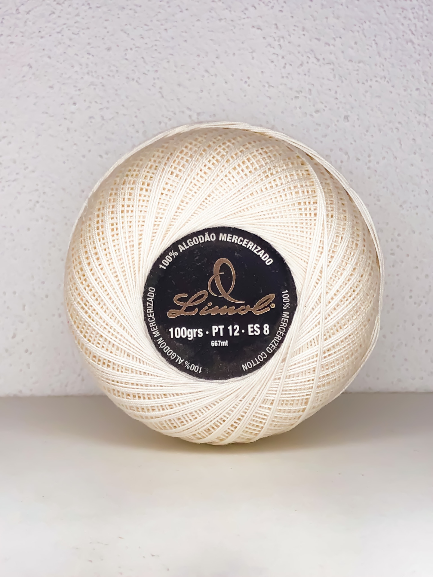 Rolo de linha em algodão mercerizado cor creme com etiqueta preta