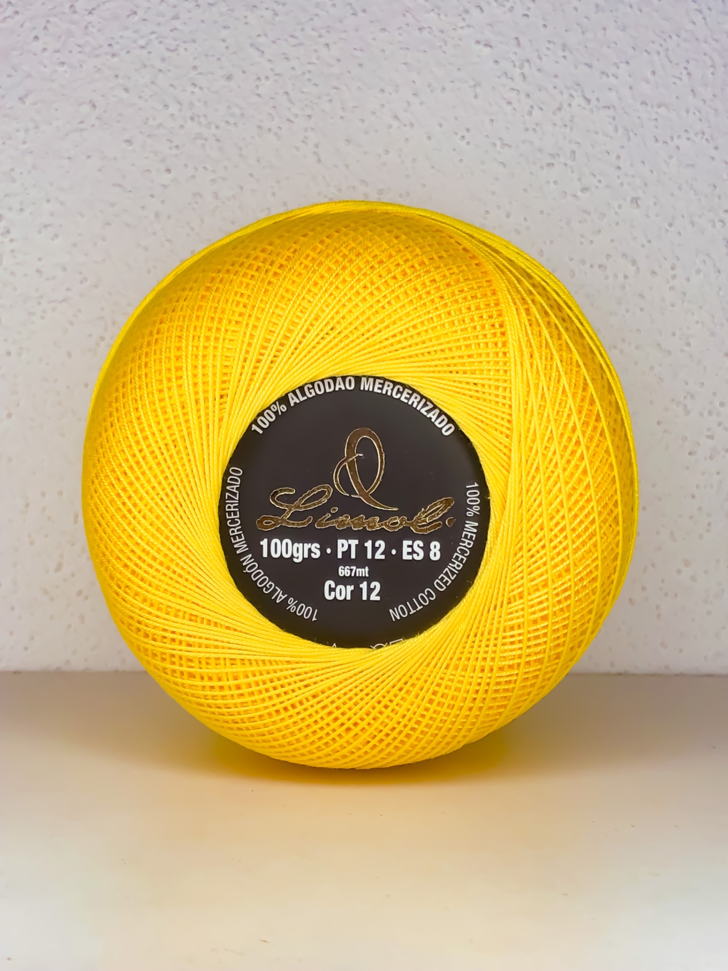 Novelo de linha de algodão mercerizado amarelo com etiqueta preta