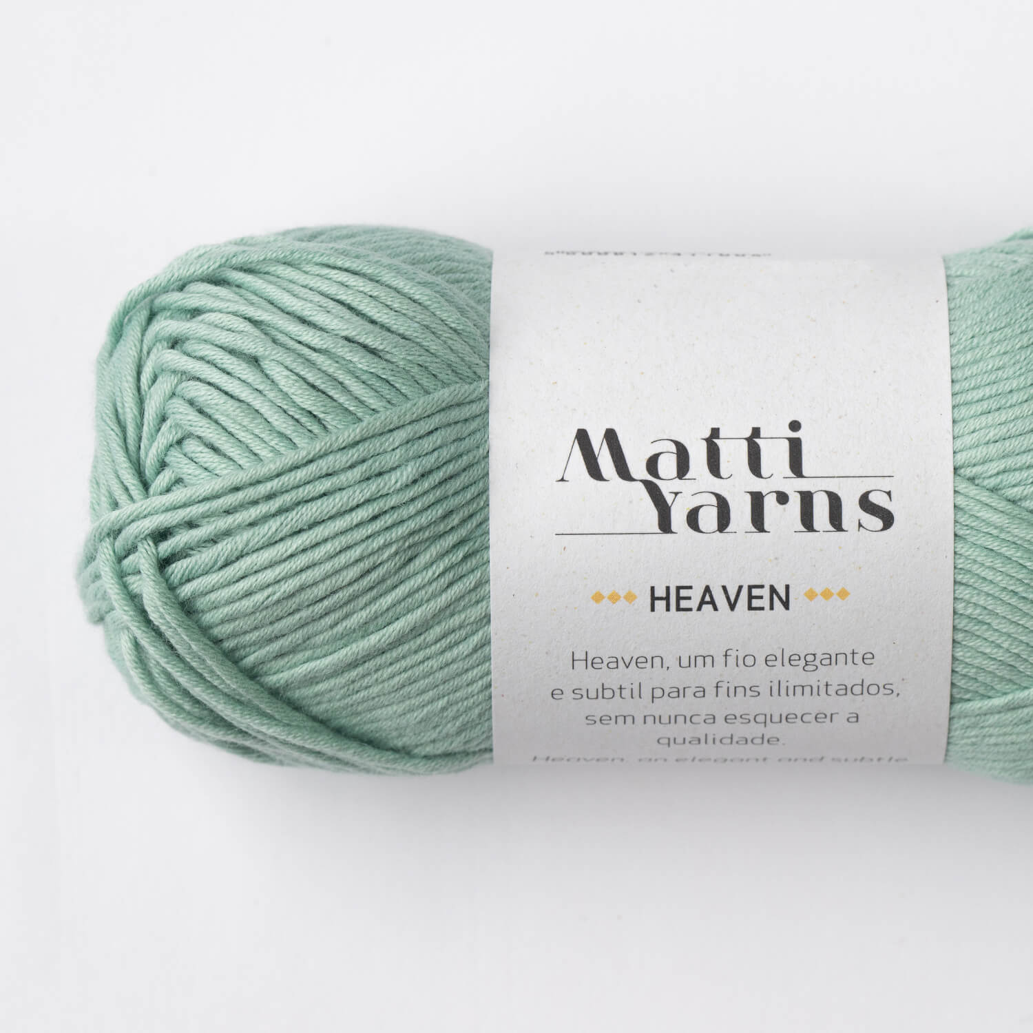 Novelo de fio de lã azul-esverdeado com etiqueta branca